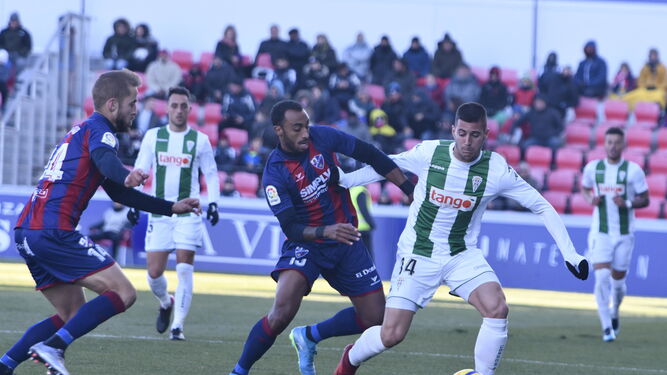 Sergi Guardiola protege el balón ante la presión de Jair, del Huesca.