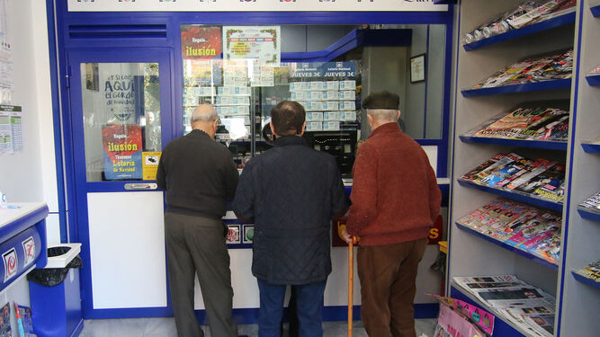Varias personas esperan su turno para adquirir lotería en una administración.