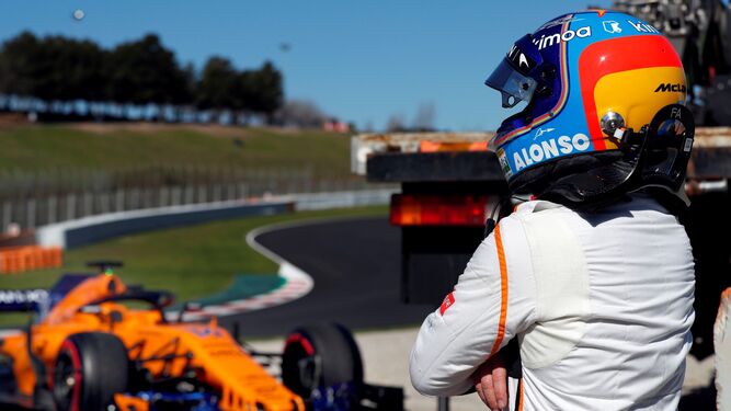 Fernando Alonso, junto a su monoplaza McLaren tras pararse por la pérdida de aceite del coche.