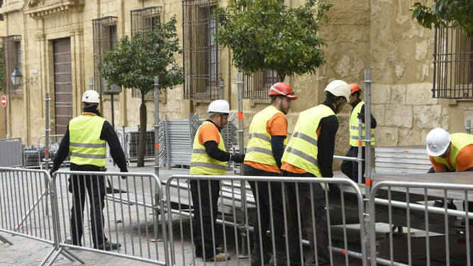 Operarios montan la carrera oficial en la calle Torrijos