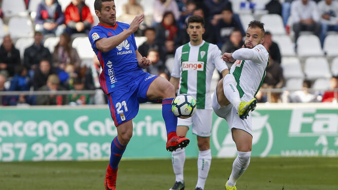 Aythami y Loureiro celebran el gol del empate ante el Oviedo, mientras Guardiola corre con el balón hacia el círculo central.