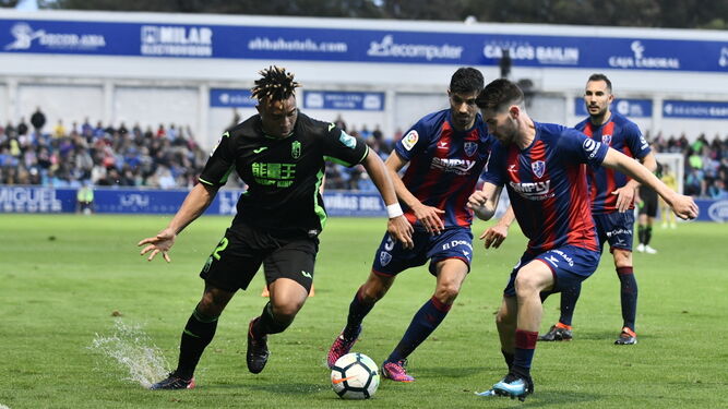 Varios jugadores del Huesca presionan a Kunde (Granada).