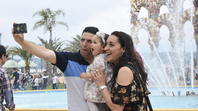 Una familia se fotografía en los alrededores de la portada de Feria.
