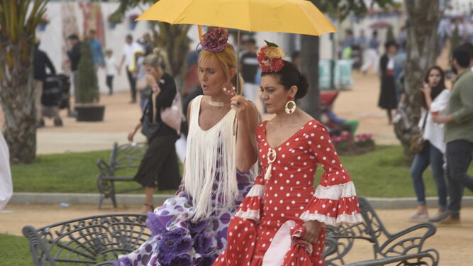Un par de mujeres avanzan por El Arenal bajo un paraguas.