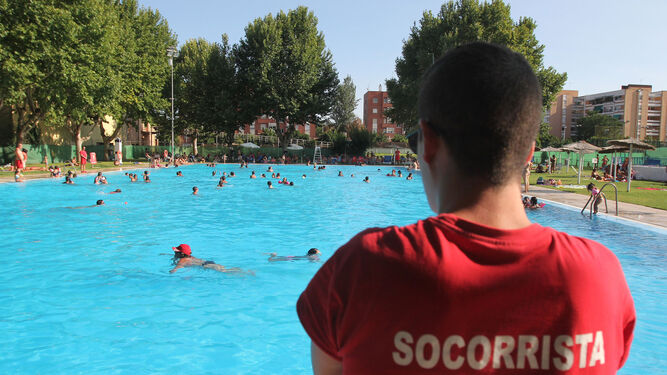 Un socorrista vigila a los nadadores en una piscina de la ciudad.
