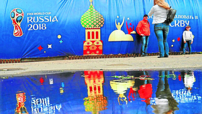 Una familia rusa se hace una foto frente a carteles con logos del Mundial colocados en Moscú.
