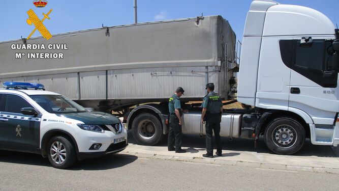 Unos agentes inspeccionan un camión.