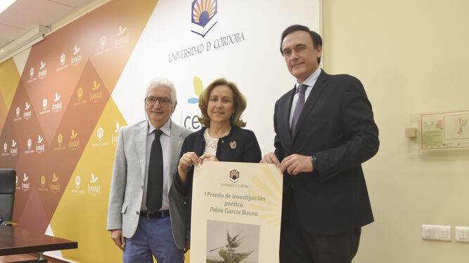 Luis Ortiz. María Rosal y José Carlos Gómez Villamandos, con el cartel anunciador del premio.