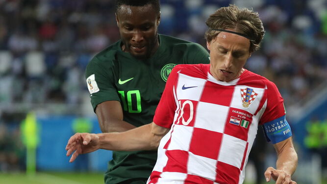 El croata Luka Modric protege el balón delante de Obi Mikel.