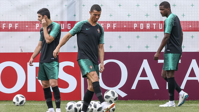 Cristiano Ronaldo juguetea con un balón en el entrenamiento entre Guedes y William Carvalho.