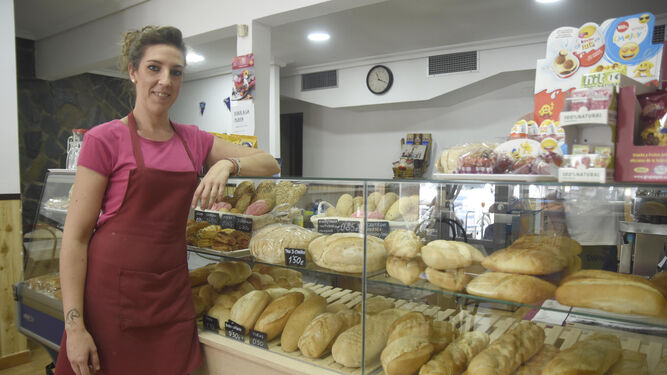Ana María Benzal, junto a la vitrina de su panadería, cargada de todas las variedades de pan que ofrece en su cafetería.