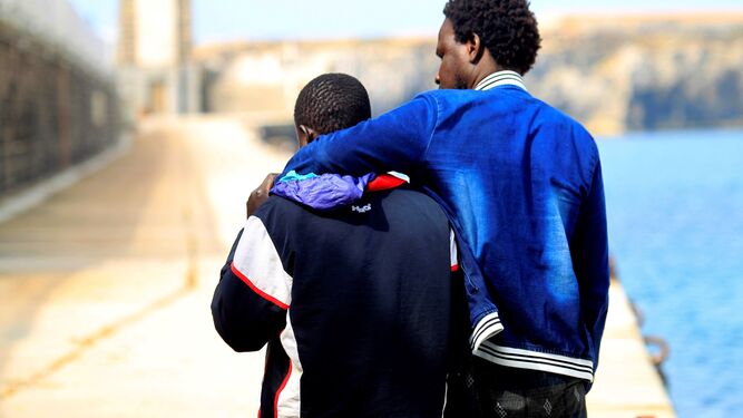 Dos inmigrantes, uno de ellos herido, ayer en el puerto de Tarifa.