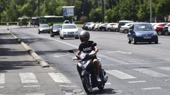 Un joven circula con un ciclomotor por el centro de la ciudad.