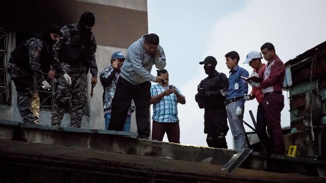 Varios efectivos de seguridad venezolanos toman pruebas en un edificio de Caracas tras el ataque del sábado.