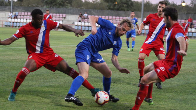 Javi Lara protege el balón ante la presión de tres jugadores del Recreativo de Huelva.
