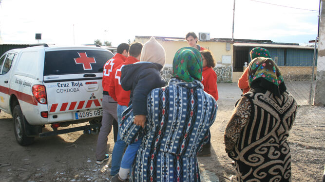 Voluntarios de Cruz Roja atienden a miembros de uno de los asentamientos cordobeses.