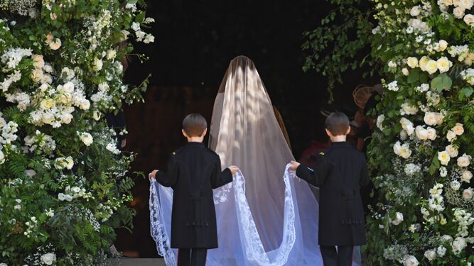 Un par de niños sostiene el velo a una novia.