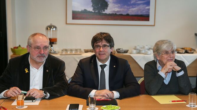 Carles Puigdemont, flanqueado por sus ex 'consellers' Lluís Puig y Clara Ponsatí durante una reunión con diputados de JxCat en Bruselas.