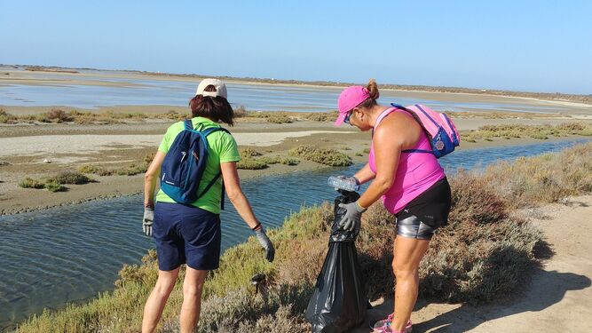 Dos mujeres, durante la limpieza de Más que Veteranas en el sendero Tres Amigos-Río Arillo.