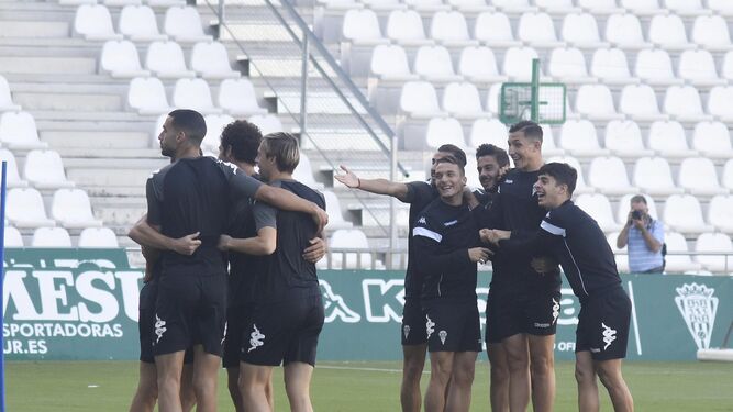 Los jugadores del Córdoba, sonrientes, durante un ejercicio de activación en el inicio de la sesión de ayer.