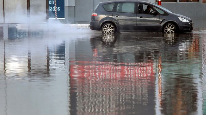 Un coche atraviesa una balsa de agua en Valencia.