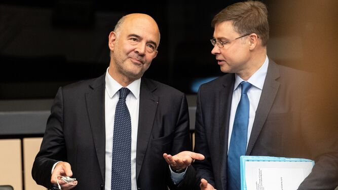El comisario europeo de Asuntos Económicos, Pierre Moscovici, conversa con el vicepresidente de la CE para el Euro, Valdis Dombrovskis.