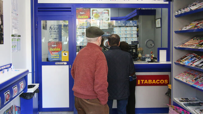 Varias personas esperan su turno en una administración de lotería.
