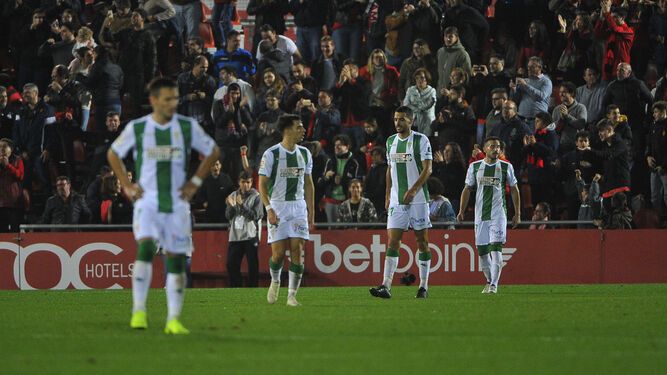 Los jugadores del Córdoba se retiran del terreno de juego con gesto serio.