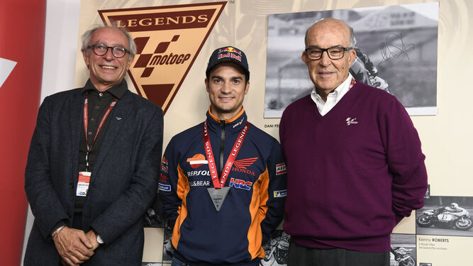 Dani Pedrosa, junto a Carmelo Ezpeleta y Vito Ippolito tras recibir la distinción de Leyenda de MotoGP.