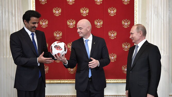 El Emir de Qatar recibe el balón del Mundial de mano de Infantino y ante Putin.