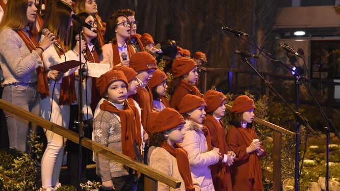Un coro actúa durante la inauguración del poblado.