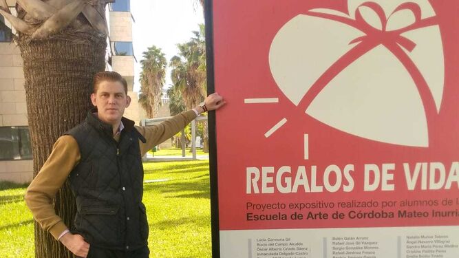 Raimundo Mínguez, junto a un cartel de la exposición sobre donación de órganos del hospital.