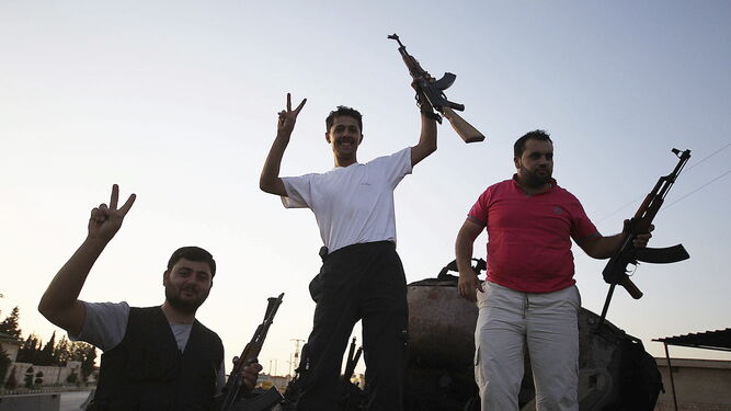 Varios milicianos enseñan sus armas en Siria