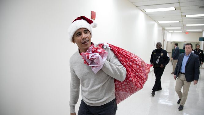 Obama llega al hospital con un gorro de Papá Noel y un saco con regalos.