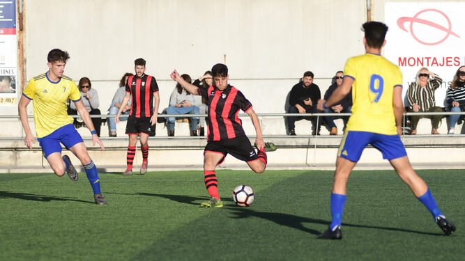 Un jugador del Séneca trata de disparar ante la presión de un jugador del Cádiz.