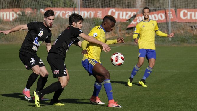 Dos jugadores del Ciudad de Lucena presionan a un jugador del Cádiz B.