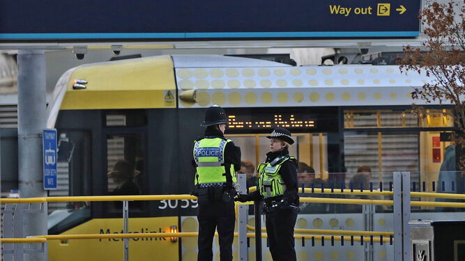 Dos agentes de policía en la estación Victoria Metrolink de Manchester donde tres personas fueron apuñaladas.