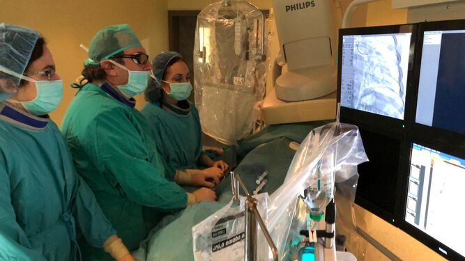 Tres profesionales del Hospital Reina Sofía realizan una intervención cardiaca a un paciente.