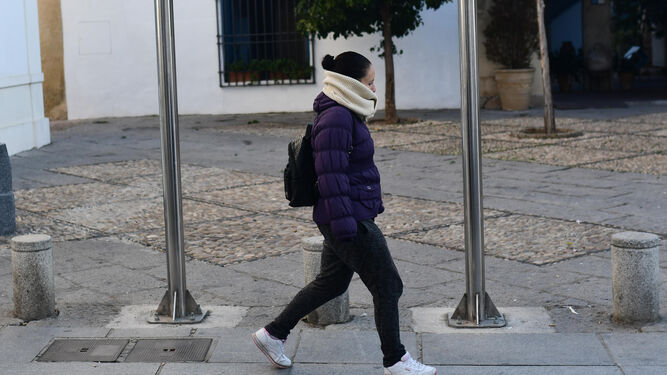 Una joven se protege del frío a primera hora de la mañana.