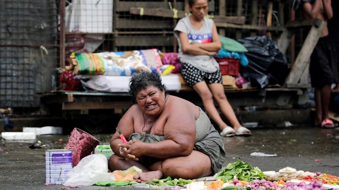 Una mujer vende verduras en una calle de Manila, en Filipinas.