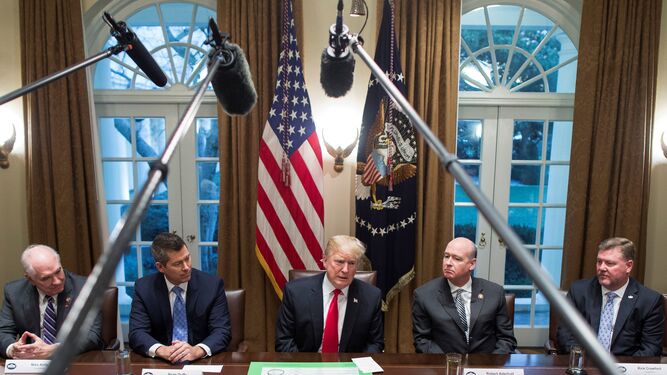 Trump (centro) comparece ante los medios en la Casa Blanca.