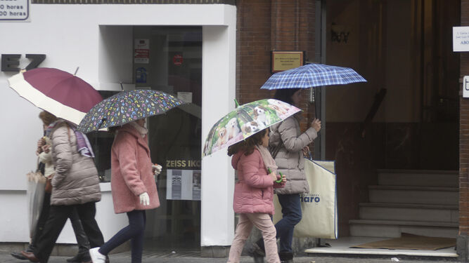 Varias personas se protegen de la lluvia con paraguas