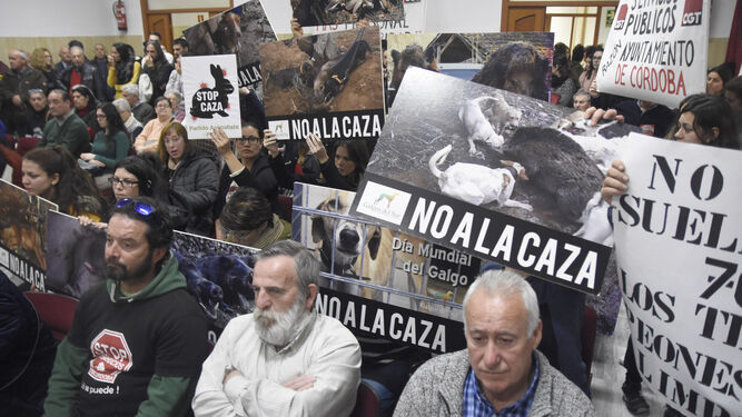 Activistas animalistas y de Pacma protestan contra la moción en defensa de la caza cartel en mano.