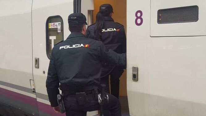 Los dos policías nacionales suben al tren en la estación de Santa Justa en Sevilla.