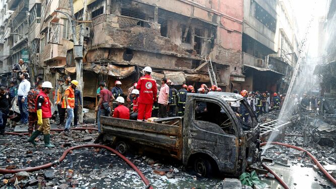 Los bomberos inspeccionan los escombros tras el incendio en Dacca (Bangladesh).