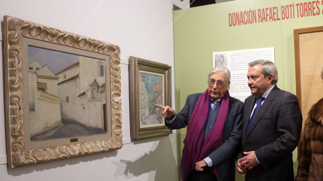 Rafael Botí Torres (izq) muestra al exdelegado de Cultura de la Junta varias obras de su padre donadas.