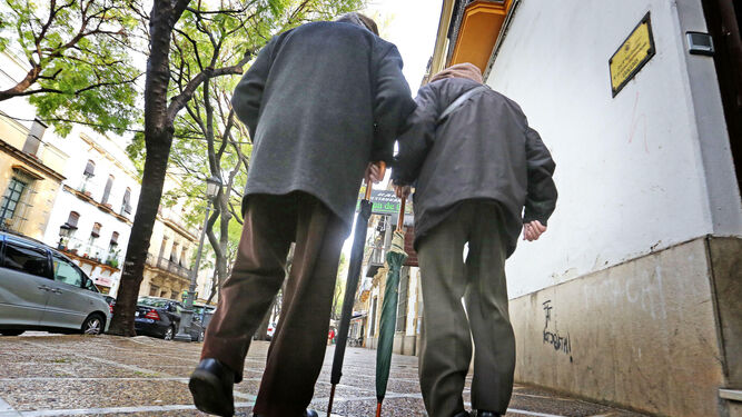 Dos mayores pasean por una calle.