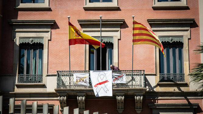 Fachada del Departamento de Interior de Cataluña con un lazo blanco con franja roja que sustituye al amarillo