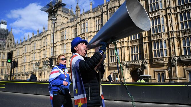 Dos activistas a favor de la Unión Europea se manifiestan frente al Parlamento británico.