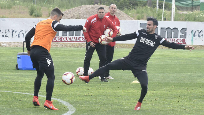 Rafa Navarro sigue una disputa de Carbonell y Alfaro con el balón dividido, en un entrenamiento.